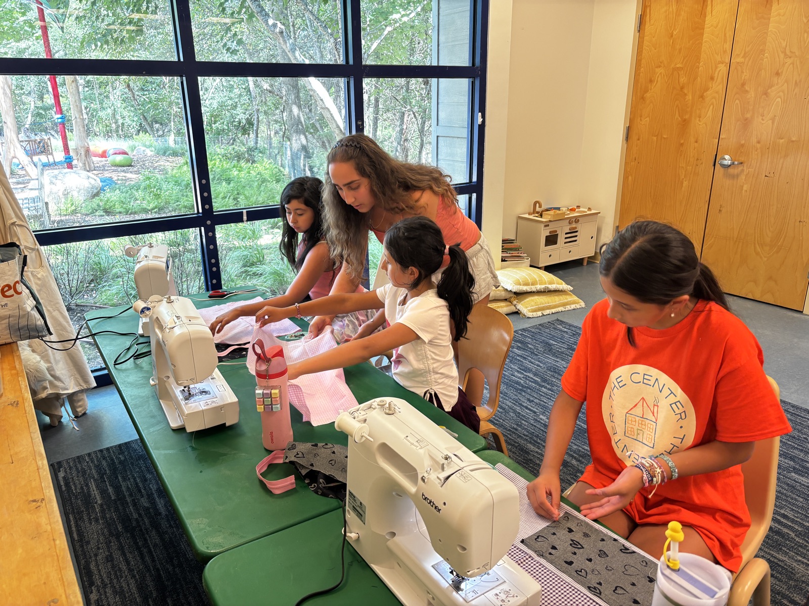 A student and teacher at a sewing machine in Winter Park, Florida